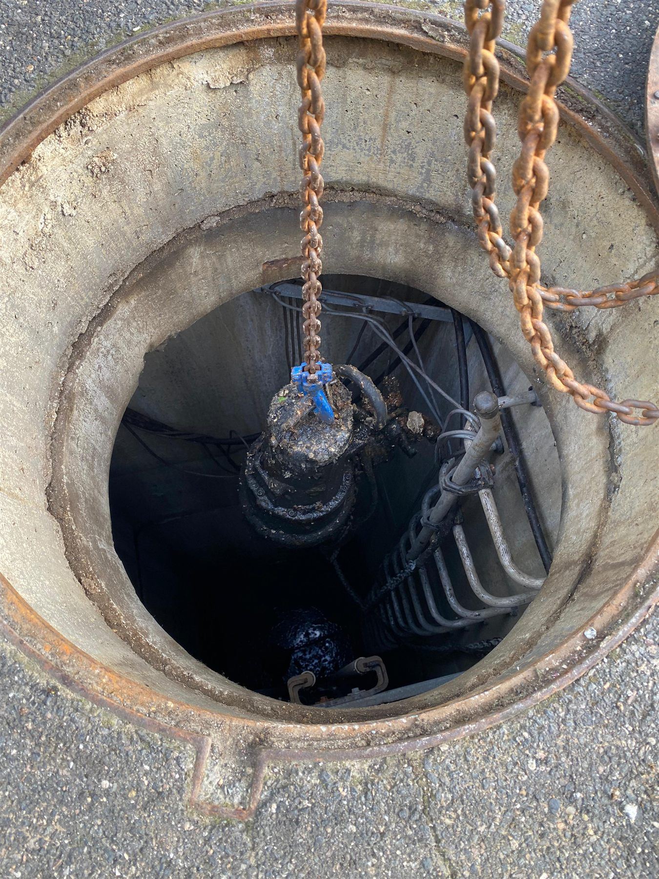Descente d'une pompe de relevage à la chaîne dans le poste, sur barre de guidage