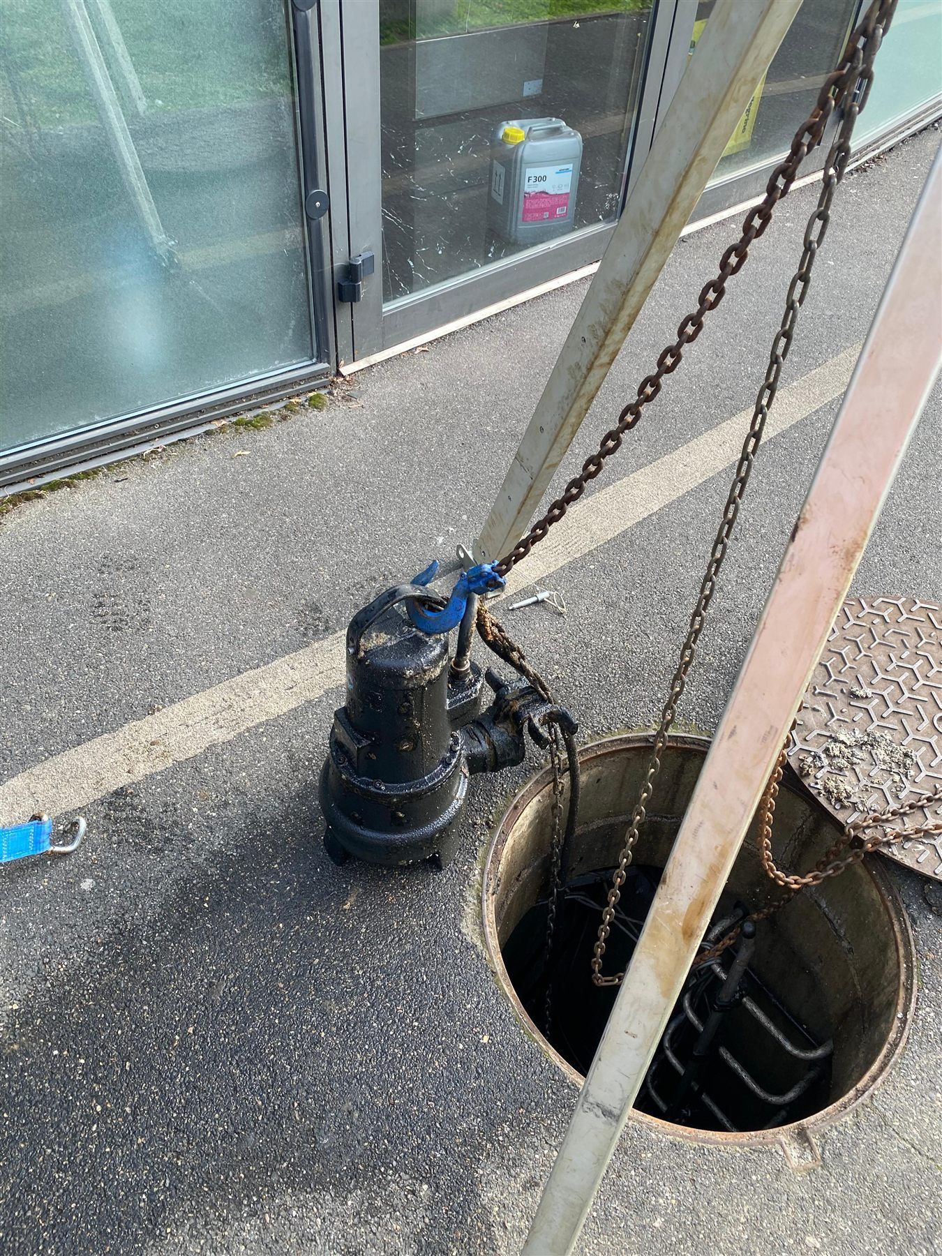 Pompe de relevage submersible remontée au palan sur trépied au-dessus du regard ouvert